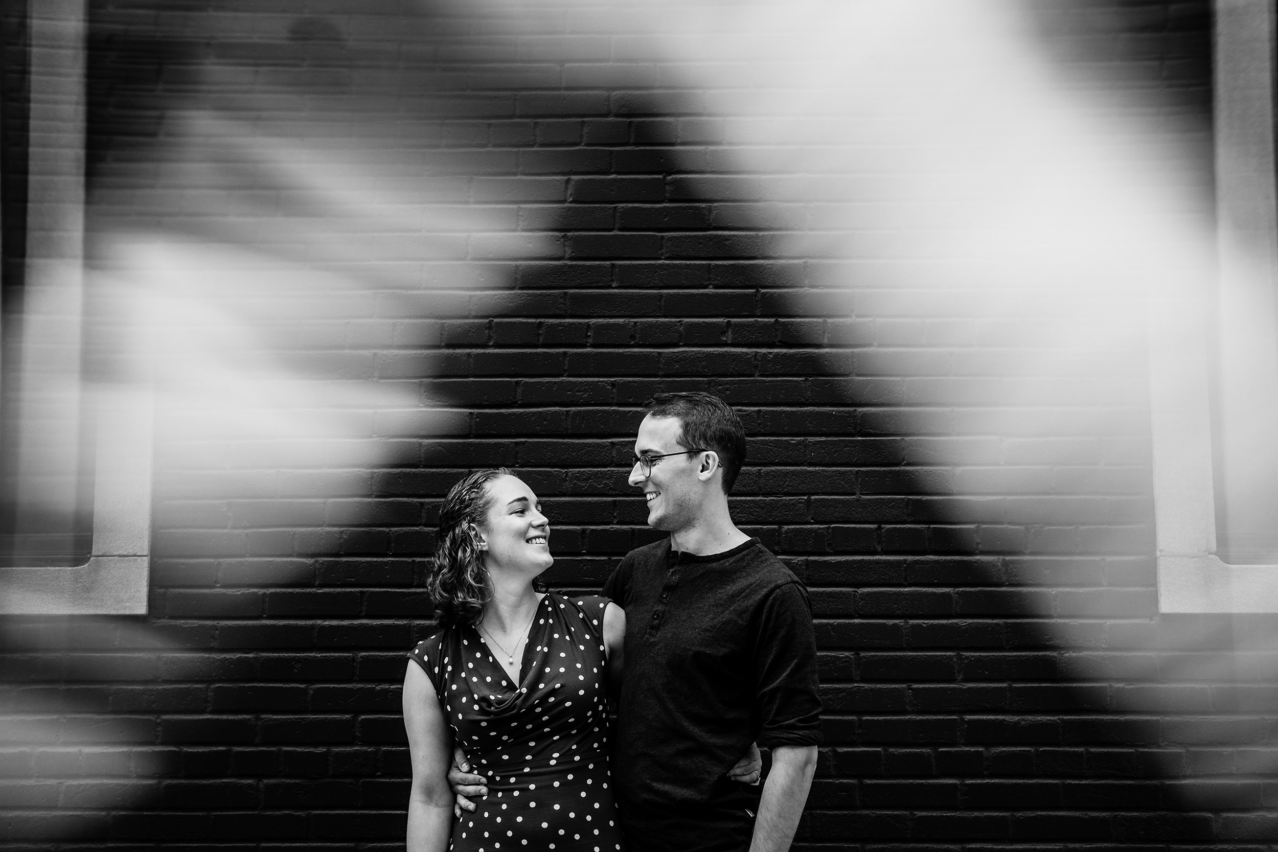 A couple laughs together in the West Loop during their engagement session.