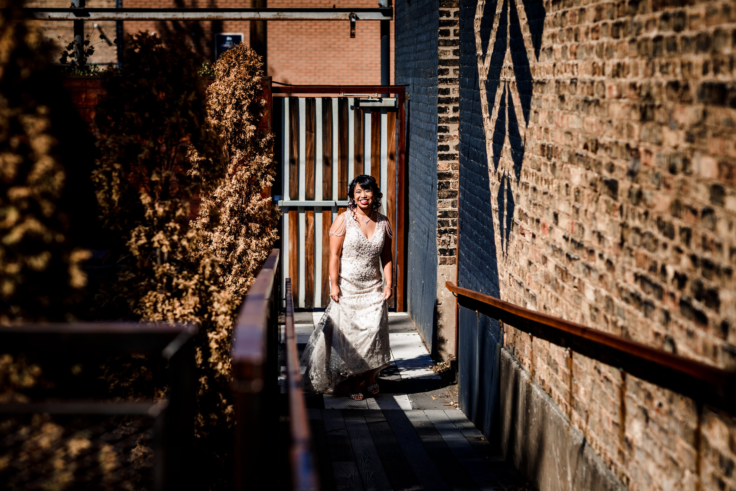 A bride smiles while walking down the aisle during her wedding at the Joinery in Chicago.