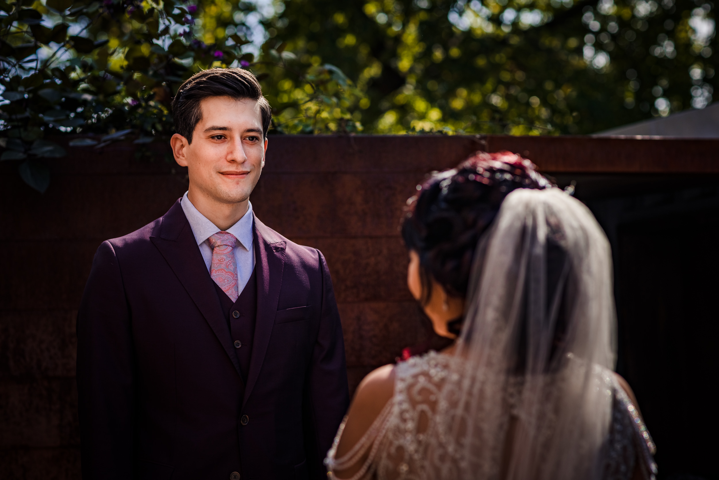 A groom smiles while seeing his bride for the first time during a wedding at the Joinery.