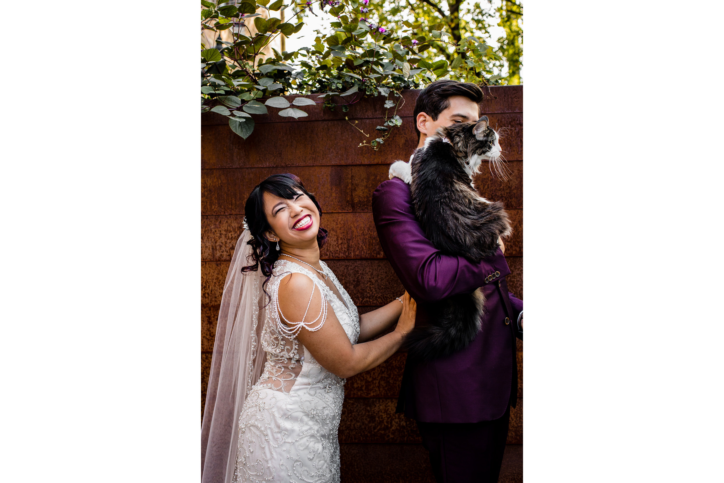 A bride laughs while her groom holds their cat after a wedding at the Joinery.
