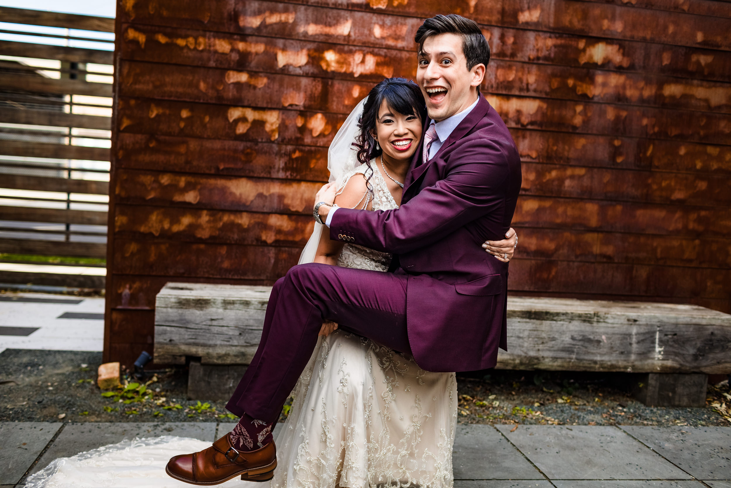 A bride carries her groom during a wedding ceremony at The Joinery.