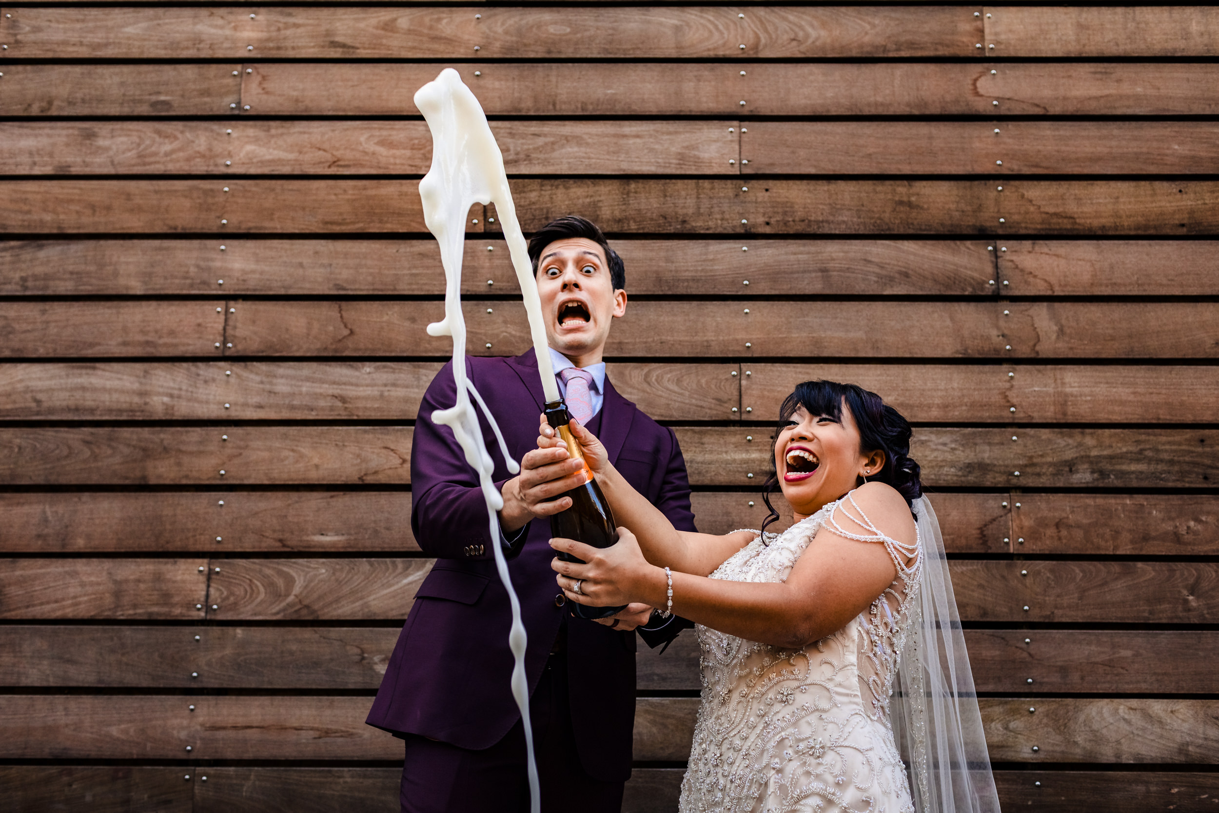 A couple reacts to a champagne bottle spraying during a wedding at the Joinery in Chicago.