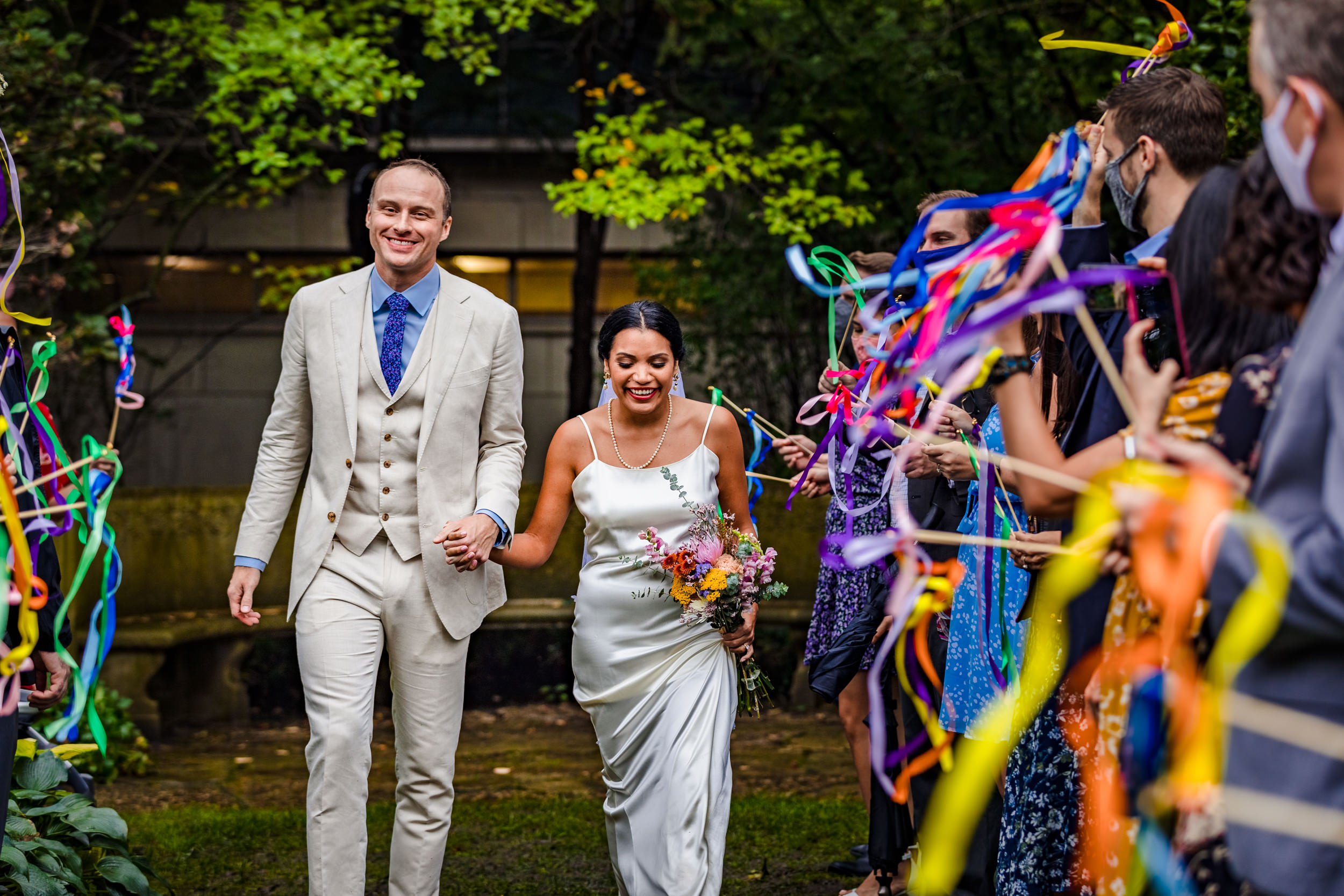 A couple walks down the aisle during a Shakespeare Garden micro wedding in Evanston.