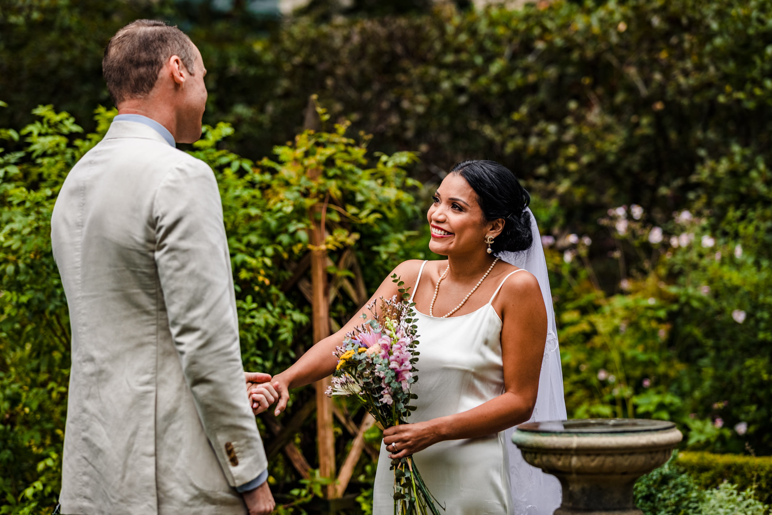 A bride smiles at her groom during a micro wedding ceremony at Shakespeare Garden in Evanston.