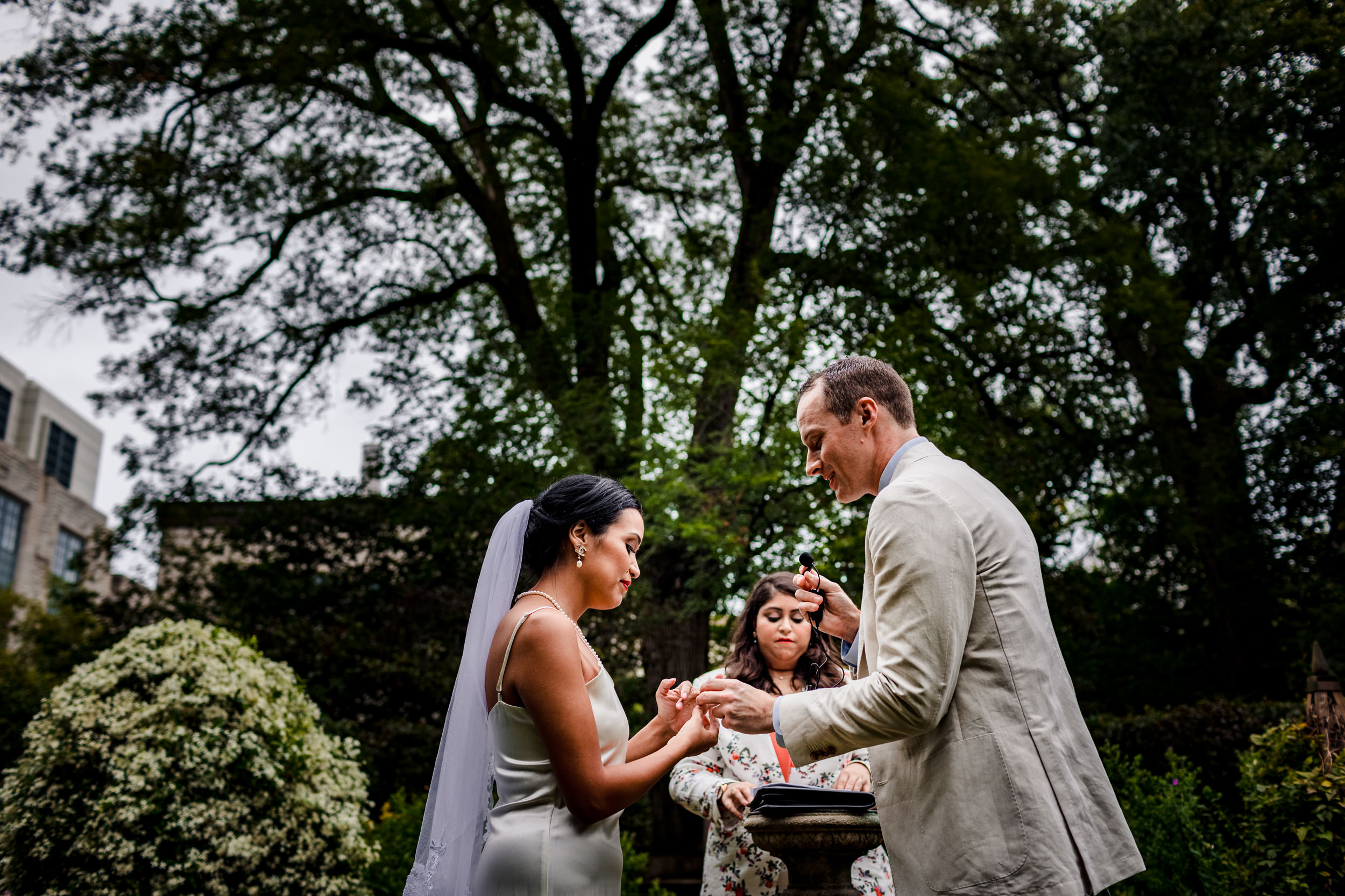 A couple exchanges rings during a Shakespeare Garden micro wedding in Evanston.