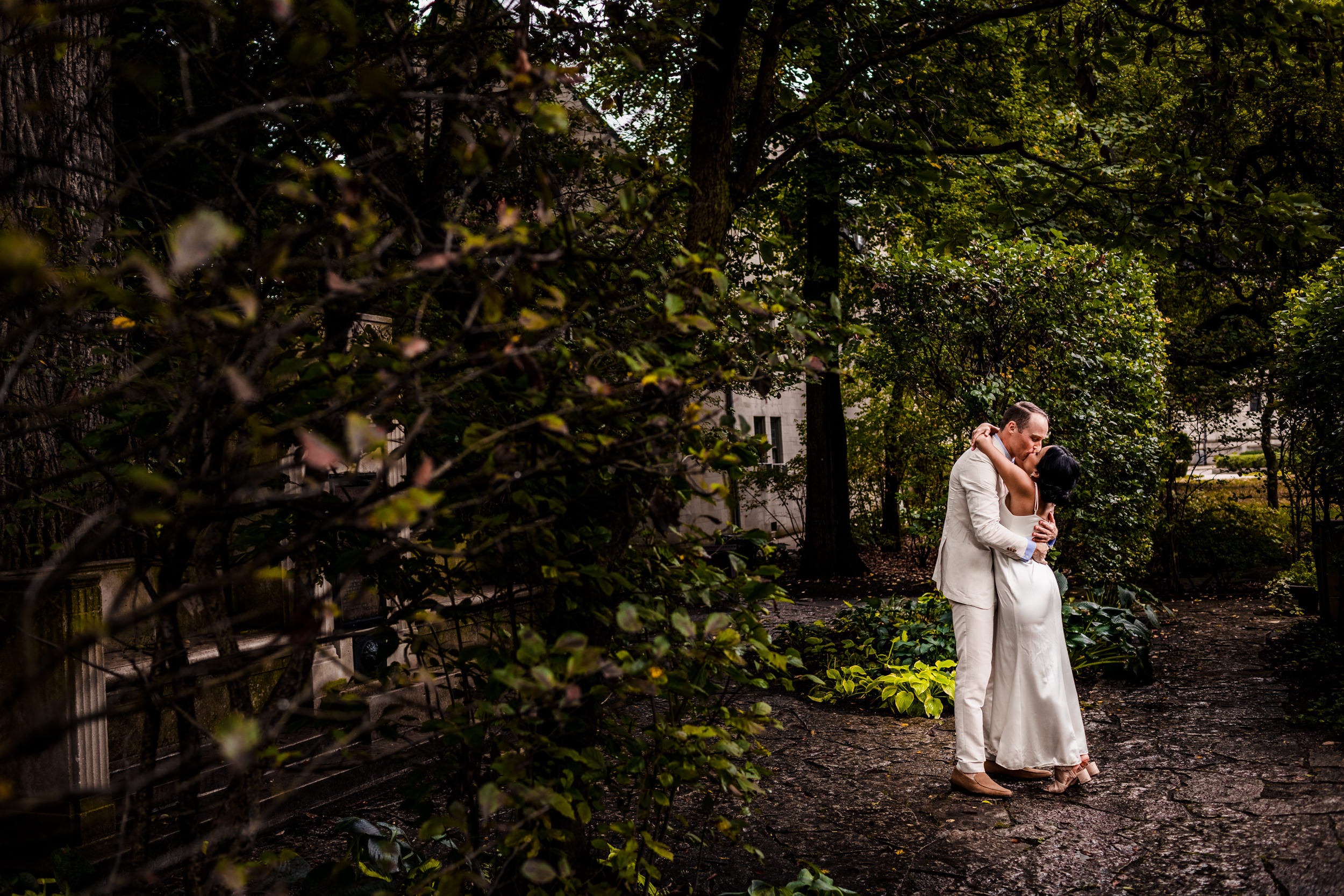 A couple laughs kisses during a Shakespeare Garden micro wedding in Evanston.