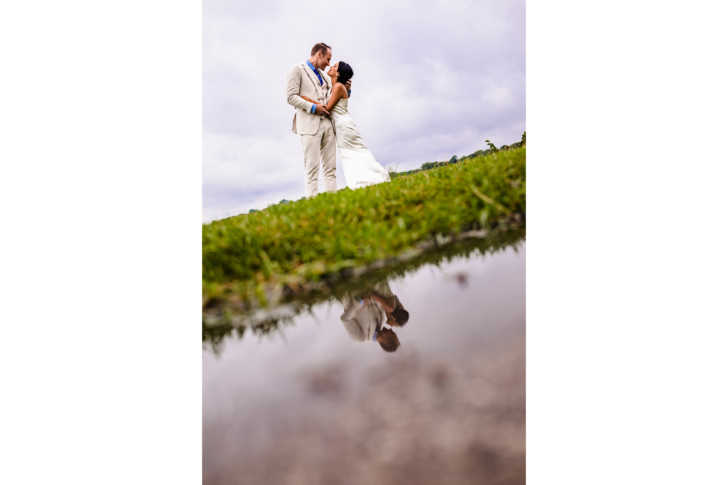 A couple hugging is reflected in a puddle at a Northwestern wedding photo shoot.