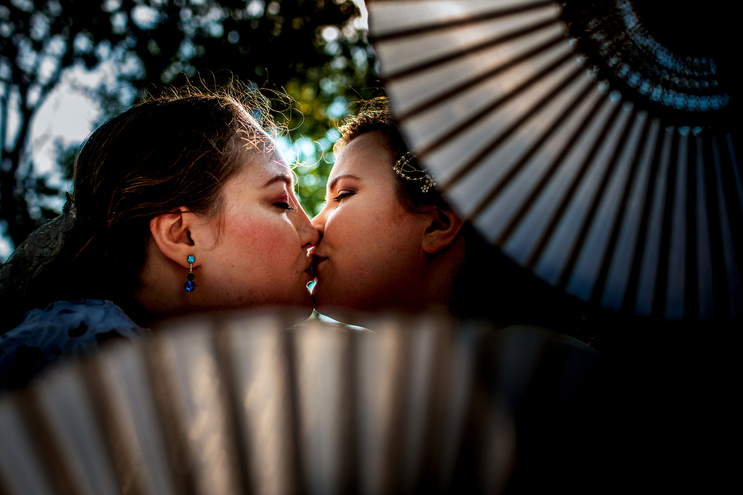 Brides kiss during a portrait session at a backyard wedding in New Lenox, Illinois.