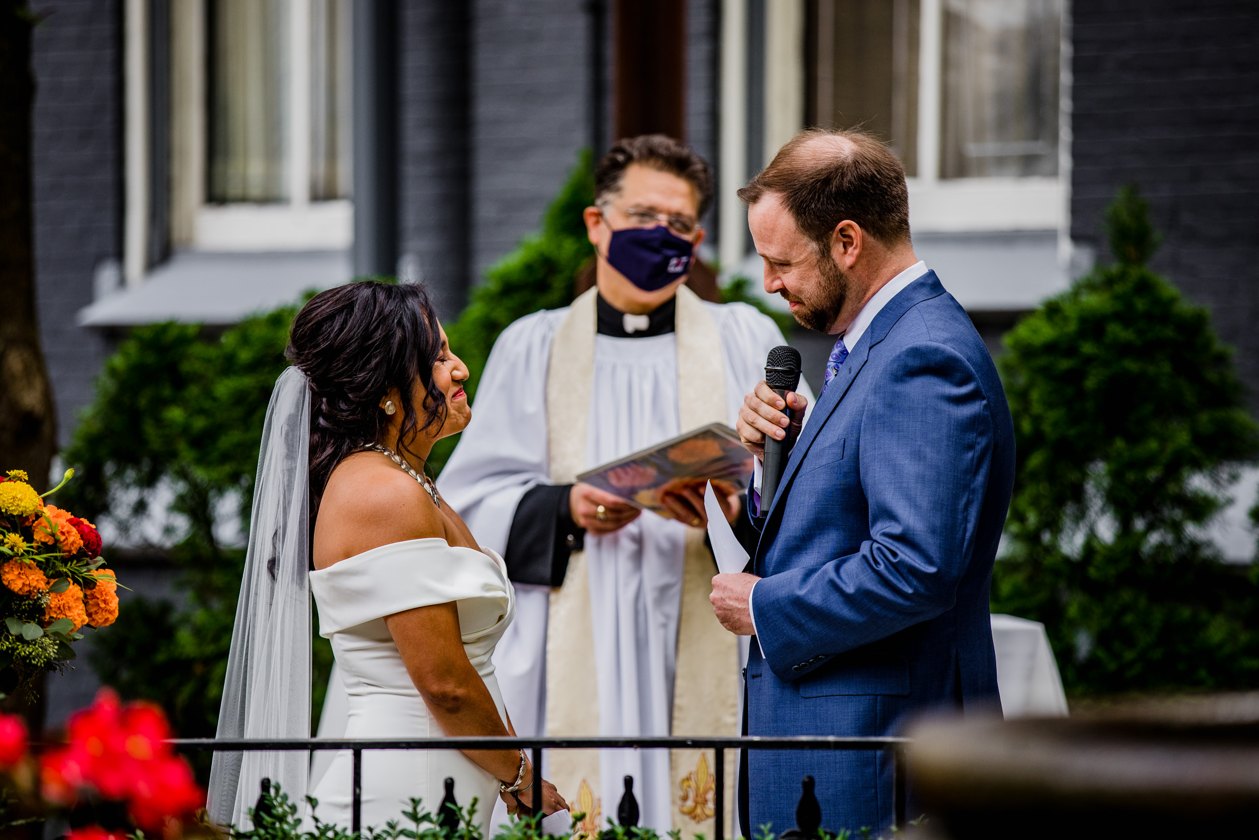 A bride reacts to her groom's vows during a Church of the Ascension garden wedding ceremony in downtown Chicago.