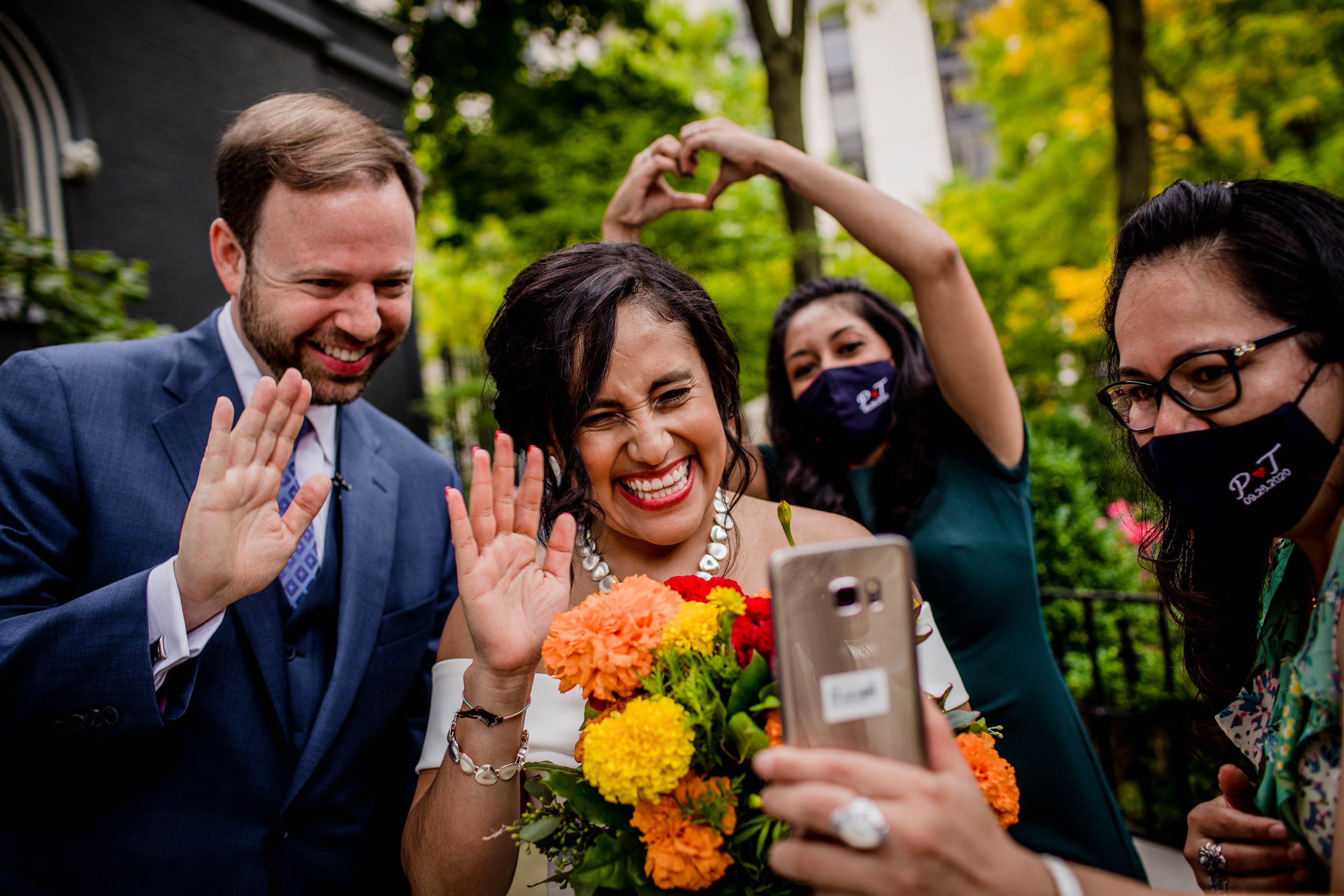 Guests greet family on an phone call during a Church of the Ascension garden wedding ceremony in downtown Chicago.