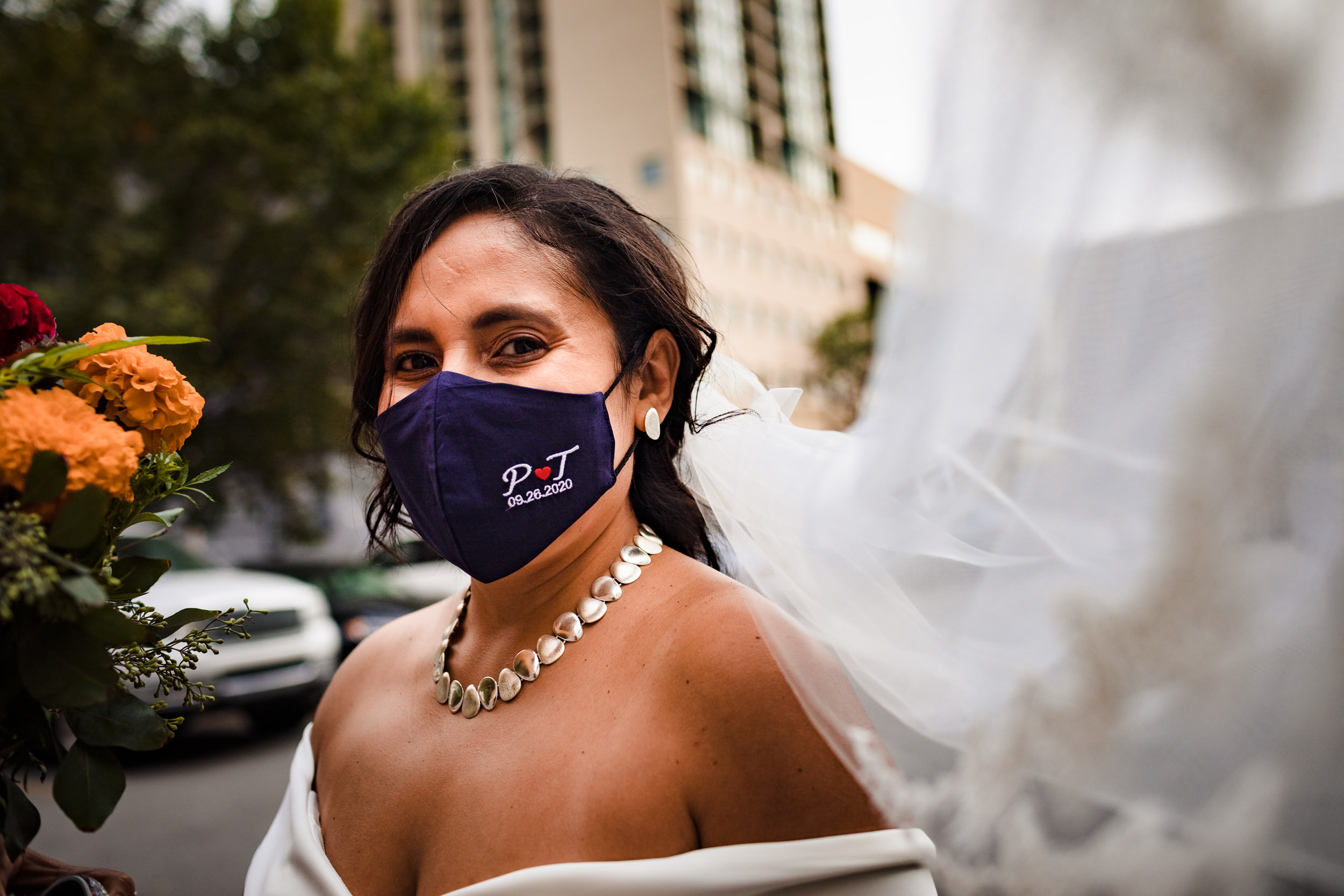 A bride's veil blows in the wind before  her wedding reception at Church of the Ascension Garden wedding.