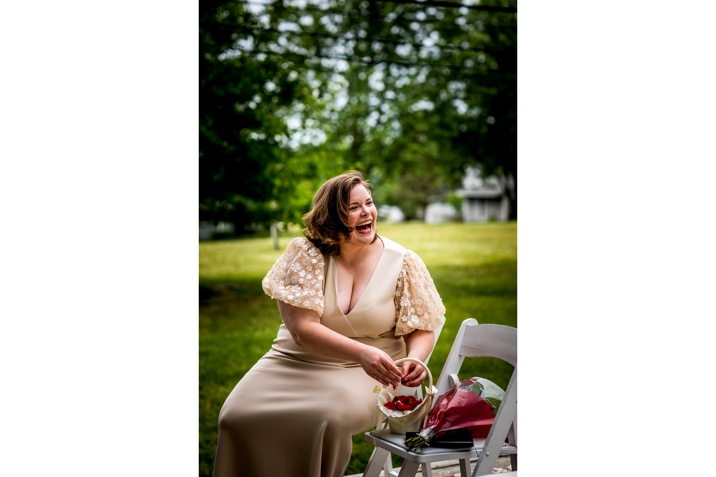 A bride laughs as guests arrive before her New Lenox backyard wedding.