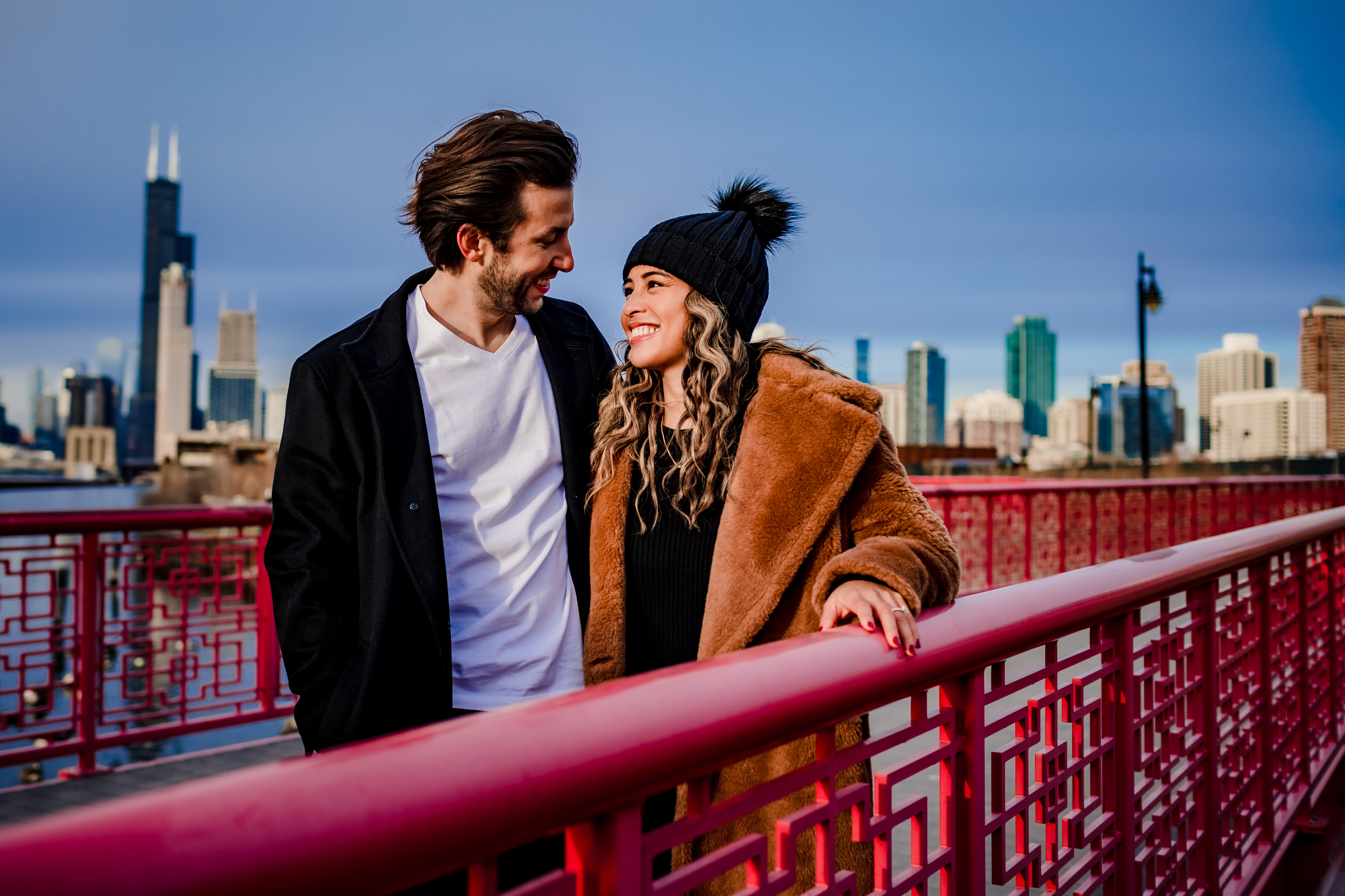 A couple laughs together during a winter engagement session at Ping Tom Park.